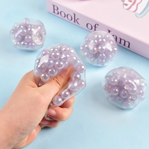 Detail of squeezing a purple beaded stress ball showing flexible texture and inner liquid