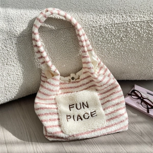 Detail der rosa-weiß gestreiften Plüsch-Einkaufstasche mit bestickter Vordertasche
