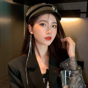 Close-up of elegant long silver tassel earrings with sparkling rhinestones on a model