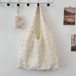 Detail of floral canvas tote bag with yellow embroidery and delicate lace hollow pattern