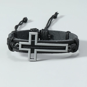 Detail view of adjustable black braided leather bracelet with silver metal cross charm