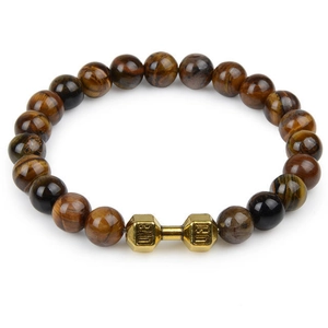 Macro view of brown tiger eye beads and golden dumbbell charm on a beaded bracelet