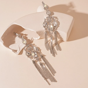 Close-up of silver drop tassel earrings with sparkling rhinestones on artistic base