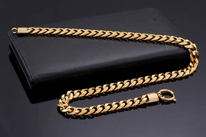 Close-up of 18K gold plated thick Cuban link necklace with sparkling rhinestone clasp
