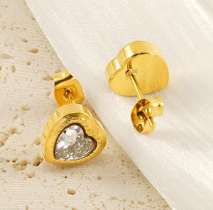 Close-up of gold heart stud earrings featuring clear zircon stones and butterfly backings