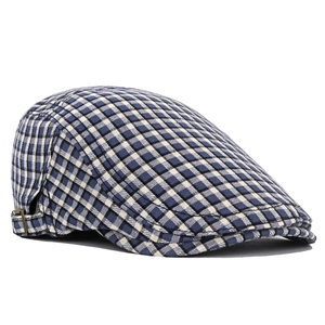 Detailed side view of British plaid flat cap with adjustable metal side buckle