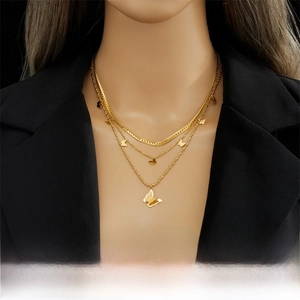 Detail of multi-layer gold titanium steel necklace featuring butterfly pendant on model