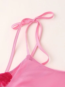Detail view of pink mesh dress featuring adjustable tie-up straps and delicate lace trim