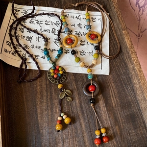 Detail of bohemian necklace with ceramic beads and antique bronze leaf pendants