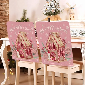 Pink Christmas chair covers with gingerbread house design in a cozy festive setting