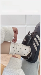 Close-up of ribbed cuffs on breathable beige cotton socks with black polka dot patterns