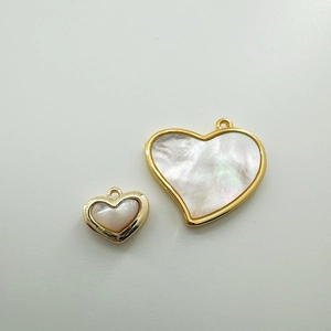 Macro detail of 18K gold plated heart charms with natural white shell for DIY jewelry