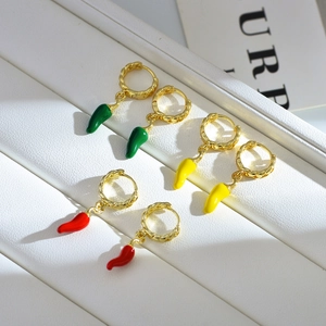 Detailed shot of red, yellow, and green chili pepper earrings with gold twisted hoops