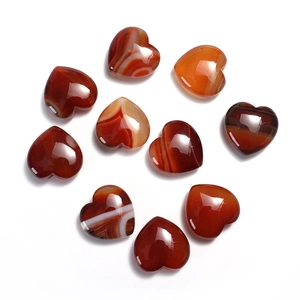 Set of ten heart-shaped polished red agate stones with natural stripes on white background