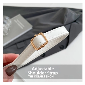 Detail of adjustable white leather shoulder strap with elegant gold metal buckle