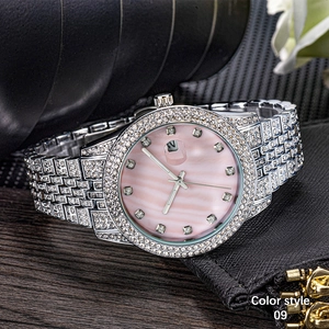 Close-up of luxury silver iced-out watch with pink mother of pearl dial and diamonds