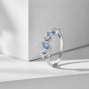 Detailed shot of S925 silver ring with blue pear-cut zircon on white geometric stone