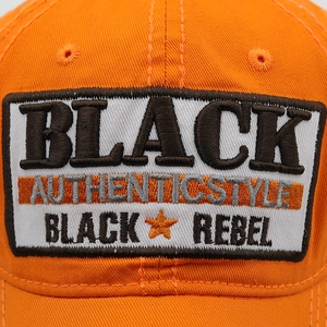 Macro shot of high-quality black letter embroidery on orange cotton baseball cap