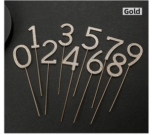 Macro shot of gold rhinestone cake toppers featuring glittering numbers zero to nine