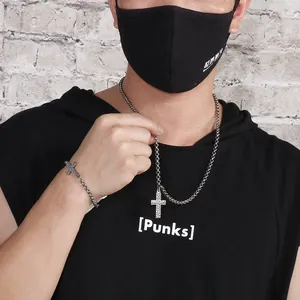 Detail of vintage punk style cross necklace and bracelet set on a male model