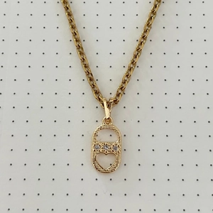 Detailed macro view of gold-toned necklace with heart-shaped pendant and cubic zirconia