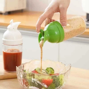 Two plastic squeeze bottles for condiments used to pour dressing into a salad bowl