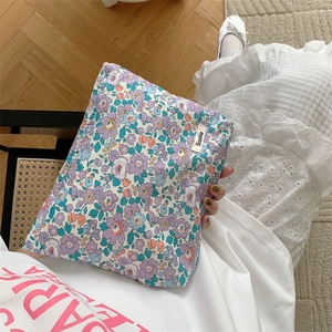 Close-up of hand holding a purple floral cotton pouch with elegant vintage patterns