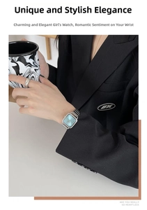 Detailed view of square blue dial watch with silver steel strap on model wrist