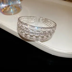Elegant multi-layer silver open bangle featuring rows of white crystals and round pearls