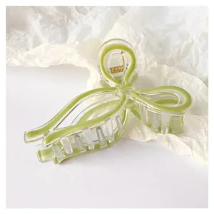 Detail of elegant jelly green bow hair claw clip made of clear acrylic with gold spring