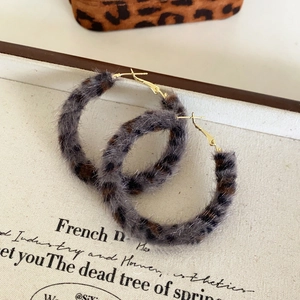 Détail de boucles d'oreilles rondes vintage imprimé léopard sur un livre rétro élégant