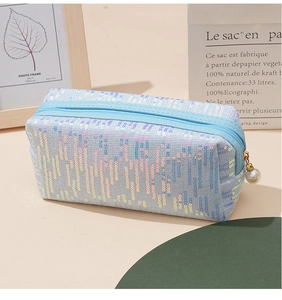 Detailansicht der hellblauen Pailletten Kosmetiktasche mit Reißverschluss und Perle.