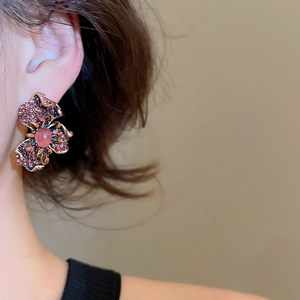 Gros plan de boucles d'oreilles fleurs avec strass roses portées par un mannequin