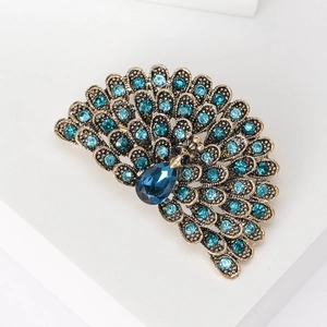 Detailed shot of retro peacock brooch with blue crystals and antique bronze finish