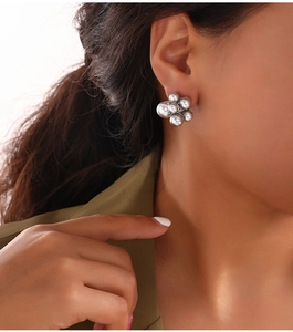Close-up of elegant silver clustered pearl earrings worn by a model in soft lighting