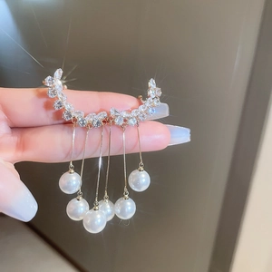 Macro view of gold tassel earrings with sparkling crystals and elegant pearls