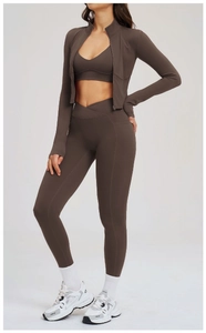 Detail of high-waist fitness leggings with side pockets and criss-cross waistband