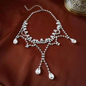 Detail of luxury teardrop tassel choker with sparkling zircons on vintage silk