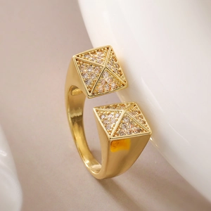 Macro shot of gold open ring featuring pyramid ends pavé-set with white zircons