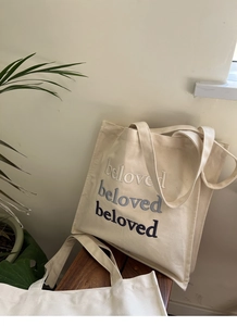 Detail of embroidered beloved letters on cream canvas tote bag for daily commute