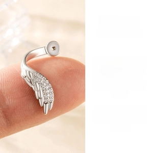 Close-up of a silver zircon-studded wing earring showing exquisite hand-set details