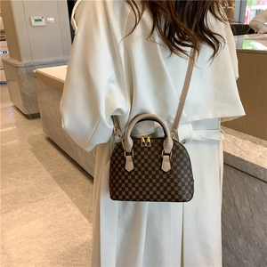 Retro brown shell crossbody bag with geometric print and cream handles in a back view