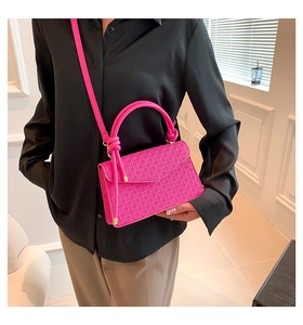 Sac à bandoulière rose vif tendance avec texture tissée porté par un mannequin