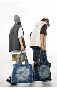Detail view of large denim tote bags with frayed patchwork in light and dark blue