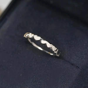 Elegant silver heart-shaped eternity ring showcased in a luxury navy blue jewelry gift box