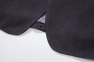 Close-up of high-quality dark grey wool coat with precise stitching and curved hem finish
