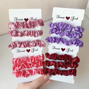 Multi-colored satin scrunchies set on display card with a soft silk sheen finish