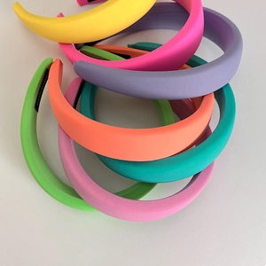 Detailed top view of handmade thick padded headbands in various vibrant neon fabric colors