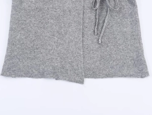 Detailed macro view of the grey knitted texture and elegant tie-fastening on the cardigan