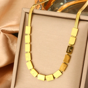 Detailed close-up of golden snake chain necklace with LOVE engraved rectangular plates